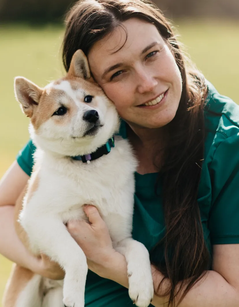 Dr. Danielle Kepler holding a tan and white Shiba Inu dog
